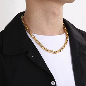Model wearing a gold square link titanium necklace in hip hop rock style on black shirt