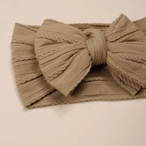 Détail du bandeau tricoté kaki avec grand nœud en tissu côtelé pour bébé fille