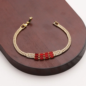 Dettaglio del bracciale dorato regolabile con pietre rosse rettangolari e zirconi incastonati