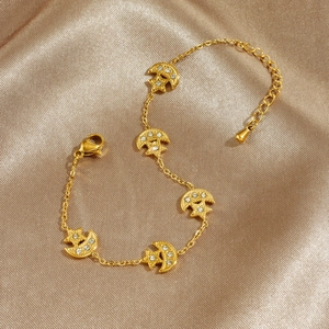 Gold plated stainless steel bracelet with moon and star charms on champagne silk