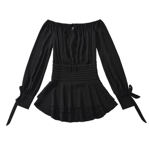 Détail de la robe noire à épaules dénudées avec taille smockée et ourlet à volants