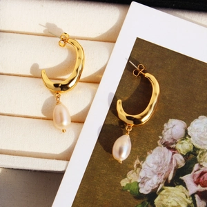 French retro gold crescent earrings with natural pearls and hammered texture on floral card