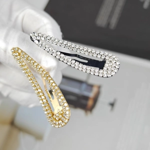 Macro shot of gold and silver water-drop hair clips with sparkling rhinestones detail