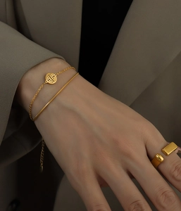 Detailed view of 18k gold double-layered snake chain bracelet with Chinese Xi character