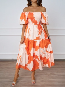 Détail de robe longue à fleurs orange avec col bardot et taille nouée élégante en mousseline