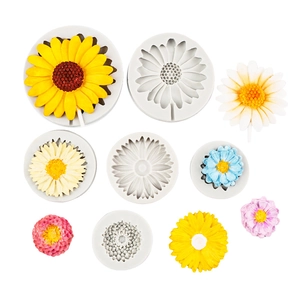 Flat lay of sunflower and daisy silicone molds with colorful fondant flower samples