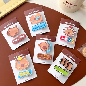 Close-up of six Capybara themed acrylic hair clips with cute cartoon designs and text
