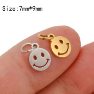 Pair of gold and silver smiley face charms on fingertip, stainless steel 7mm size