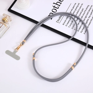 Cordino per cellulare in nylon grigio regolabile con ganci dorati su scrivania bianca minimal