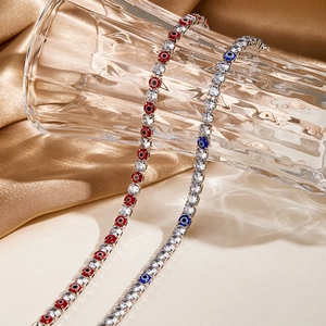 Detail of luxury evil eye tennis bracelets with red and blue crystals on gold silk