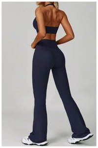 Back view of high-waisted flared yoga pants and racerback sports bra in dark blue