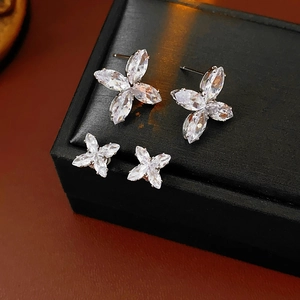 Gros plan détaillé de boucles d'oreilles fleur en zircon sur un écrin en cuir noir