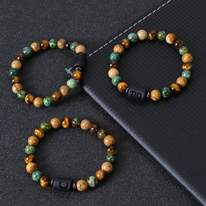 Tiger eye and jasper beaded zodiac bracelets set on textured black background