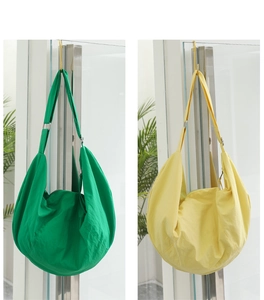 Dettaglio di grandi borse a tracolla in nylon verde e giallo con cinghie regolabili