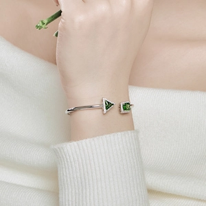 Detailed close-up of S925 silver spring bangle with green square and triangle emerald stones