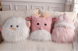 Close-up of plush Christmas snowman and gnome pillows on a soft white sofa