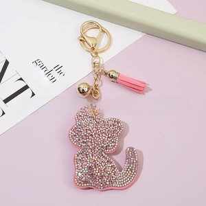 Detail view of pink crystal cat keychain with gold bell and tassel charm accessory