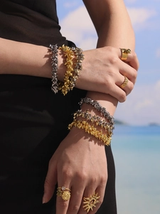 Punk style gold and silver spike bracelet and ring set worn by model on beach