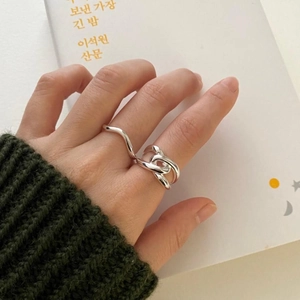 Detailed view of 925 silver rings with crisscross hollow design worn on hand