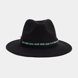 Détail d'un chapeau fedora noir en feutre avec ruban décoratif en perles bleues