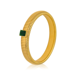 Detailed view of a gold-toned ribbed cuff bracelet featuring a green emerald zircon stone