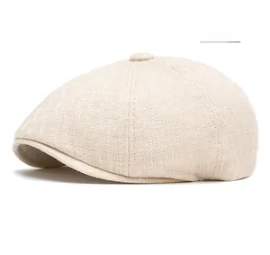 Detailed close-up of beige cotton linen flat cap showing woven fabric texture and top button