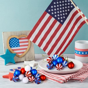 Patriotic 4th of July ornaments featuring USA flag patterns and stars on a wooden table