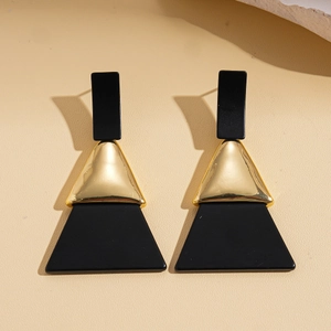 Gros plan détaillé de boucles d'oreilles géométriques avec triangles dorés et résine noire