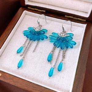 Detail of blue floral crystal tassel earrings with silver chains in a premium wood box