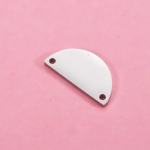 Close-up of a semi-circular mirror-polished stainless steel pendant with double holes