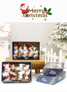 Detailed view of plush Santa Claus figurines in festive gift boxes for Christmas decor