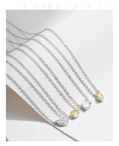 Detailed view of silver necklaces with geometric yellow and clear crystal pendants