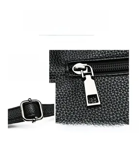 Detail of silver hardware, smooth zipper, and dual compartments on black leather bag