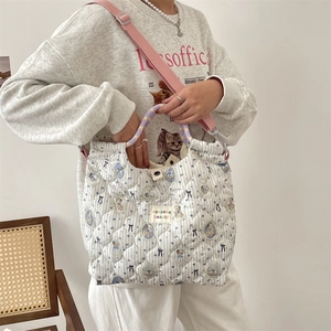 Détail du sac cabas matelassé à rayures bleues avec bandoulière réglable rose fuchsia