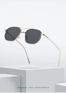 Close-up of stylish gold double-bridge metal frame sunglasses with dark tinted lenses