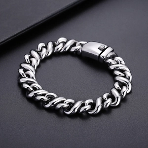 Macro detail of silver stainless steel Cuban link chain with an industrial square buckle