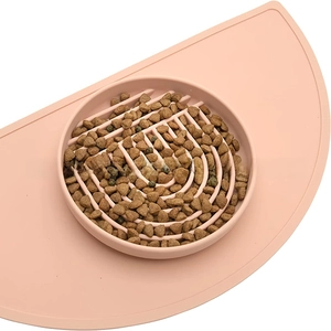 Macro detail of pink silicone slow feeder bowl with spiral maze design and matching mat