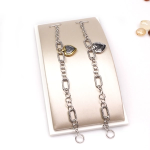 Detailed close-up of heart charm bracelets with OT toggle clasps in gold and silver finish