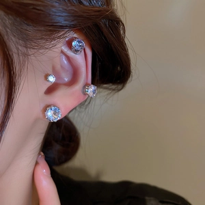 Close-up of magnetic zircon stud earrings in various sizes worn on a woman's ear