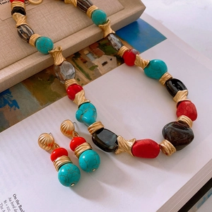 Detail of vintage bohemian jewelry set with antique gold finish and colorful resin stones