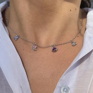 Detail of space-themed necklace with UFO and astronaut charms on a silver chain