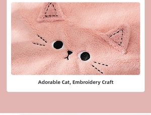 Close-up of pink coral fleece fabric featuring cute embroidered cat face detail