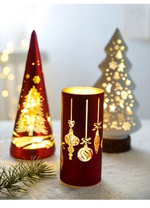Close-up of Christmas tree candle holders with glowing snowflake hollow patterns