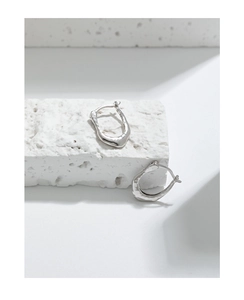Detail of S925 sterling silver earrings with irregular lava texture on stone
