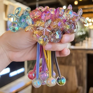 Hand holding colorful crystal cherry hair ties with iridescent acrylic beads for girls