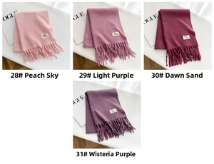 Detail of soft fringe scarves in pink, purple, and red displayed with a Vogue magazine