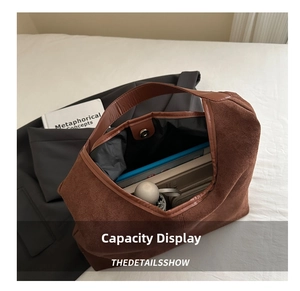 Macro view showing large capacity interior of brown faux suede tote bag with books and umbrella