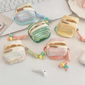 Collection of colorful tweed fabric cases for wireless earbuds with beaded lanyards