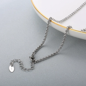 Detailed close-up of stainless steel necklace lobster clasp with adjustable extender chain