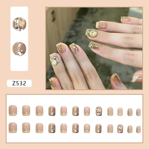 Short square press-on nails set with glitter, marble ink patterns and sparkling rhinestones